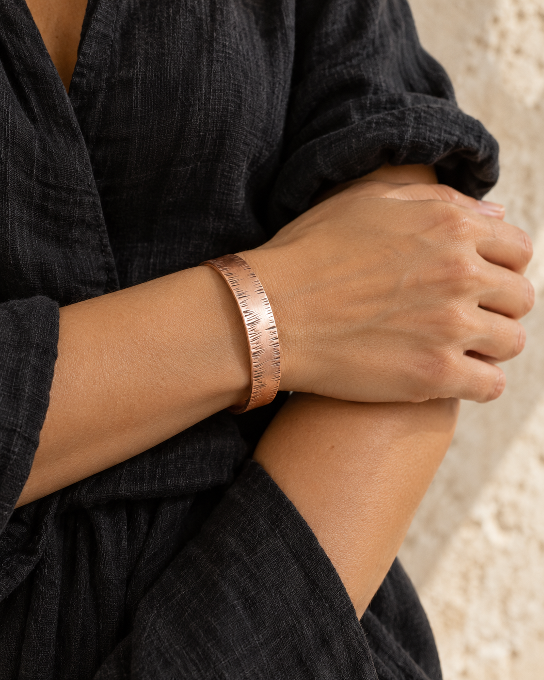 Close-up of the textured copper cuff on a female model's wrist