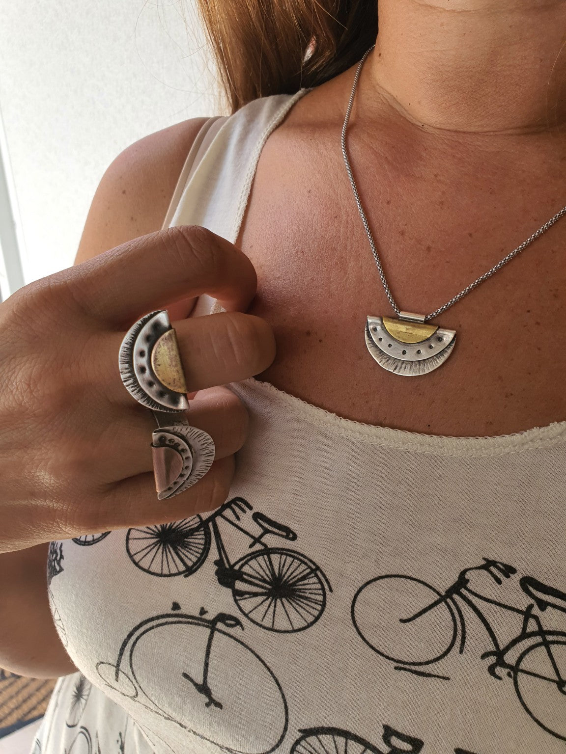 Copper and brass fan rings worn on the hand; necklace sold separately