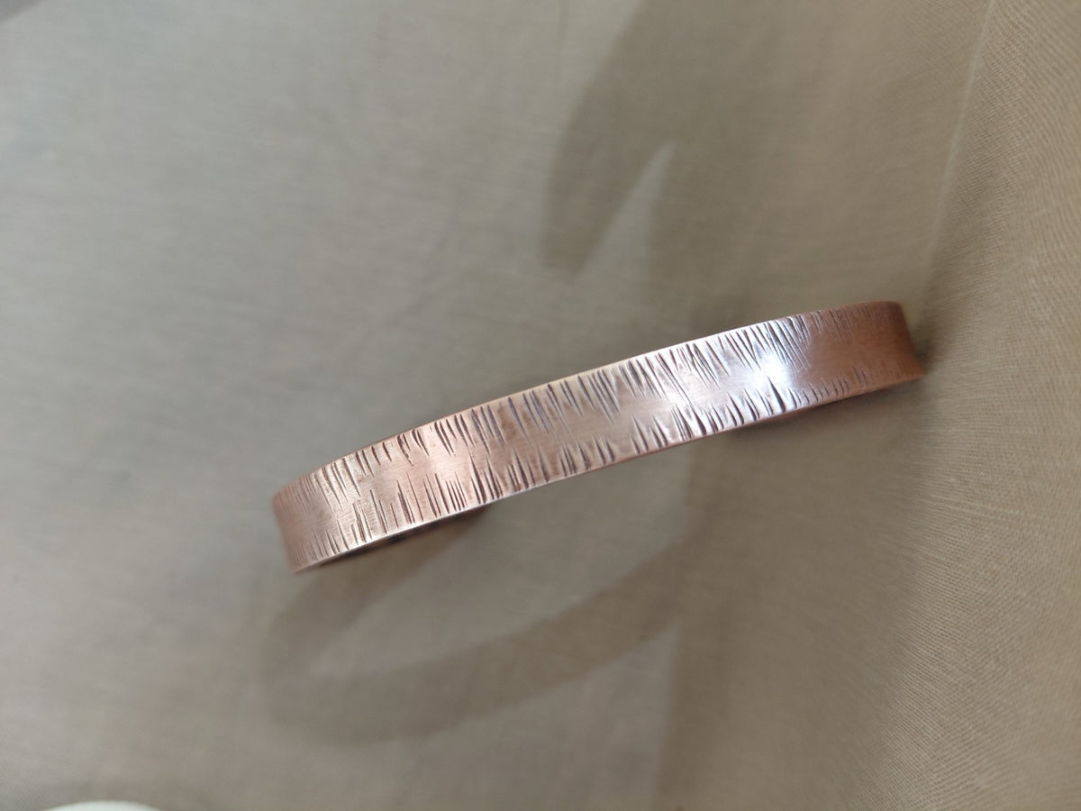 Close-up of the linear texture on the copper cuff bracelet