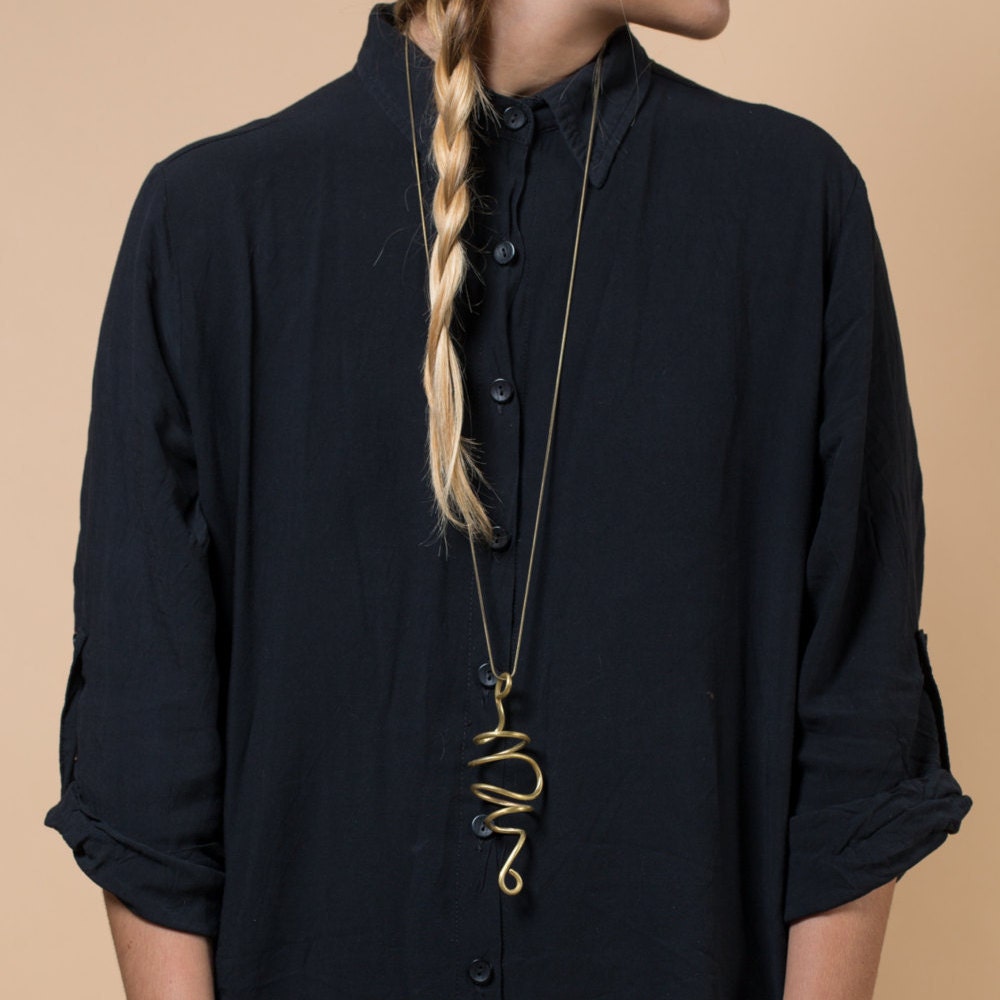 Long spiral wire pendant worn with a dark shirt